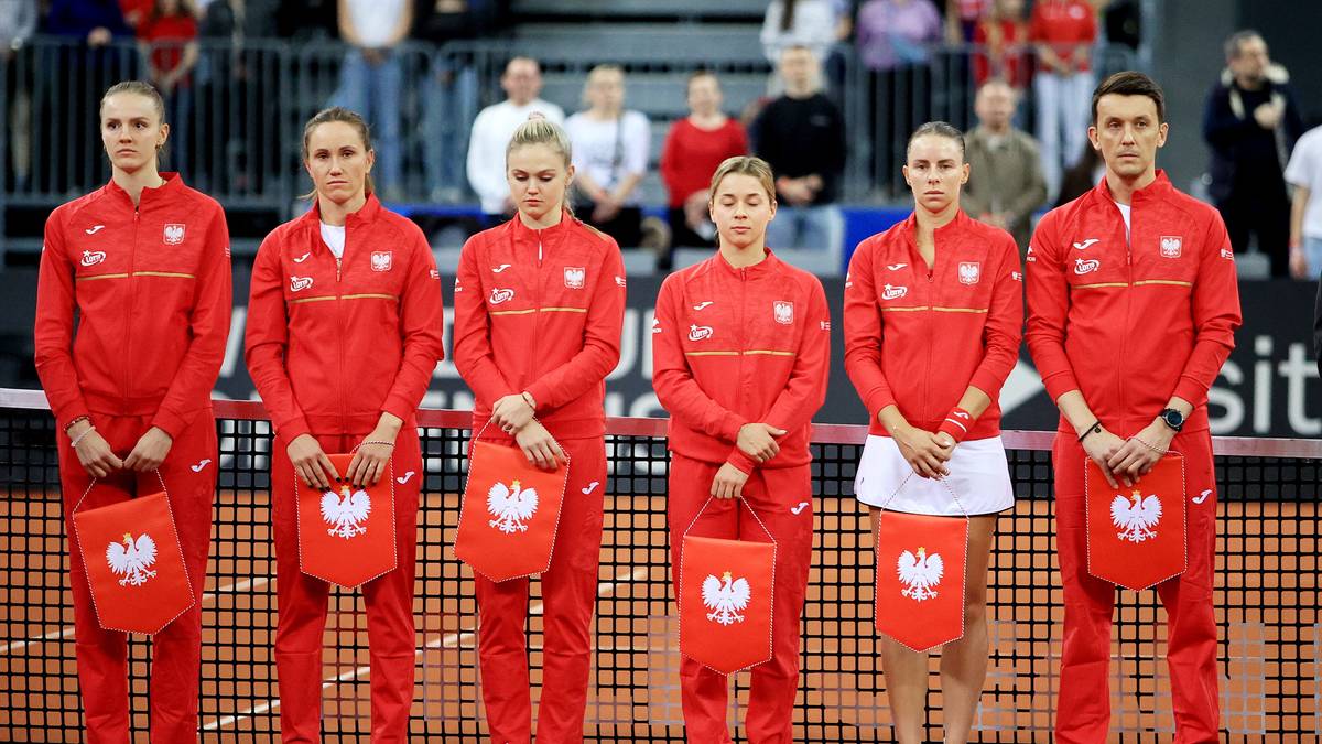 Sześcioro zawodnik&oacute;w w strojach reprezentacji Polski z flagami.