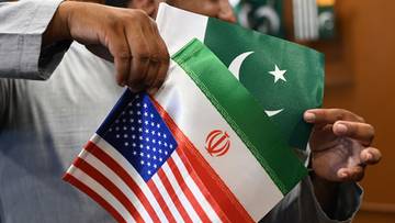 Fragment flagi Stan&oacute;w Zjednoczonych, flagi Iranu i flagi Pakistanu trzymane przez ręce.