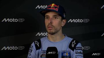 Alex Marquez w czapce z daszkiem z logo Red Bull i MotoGP, ubrany w kombinezon wyścigowy, podczas wywiadu.