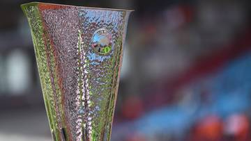 Puchar Ligi Europy UEFA z widocznym logo, na rozmyty tle stadionu z kibicami.