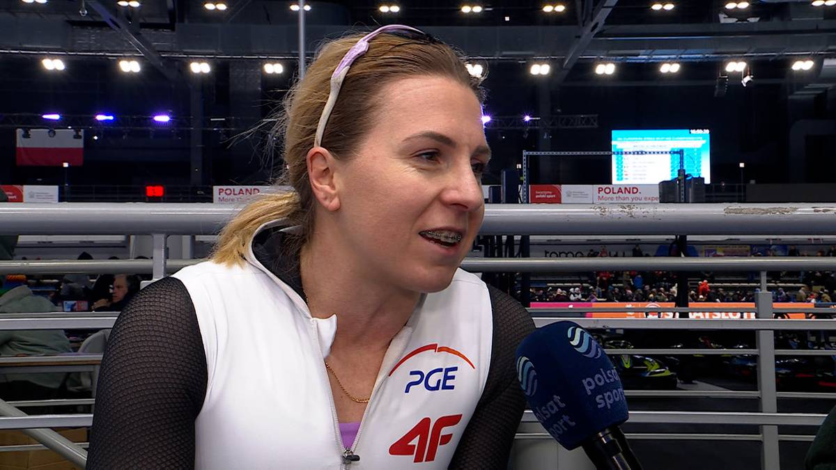 Kobieta z blond włosami spiętymi w kucyk, nosząca opaskę na głowie, w stroju sportowym z widocznym logo PGE. Trzyma mikrofon.