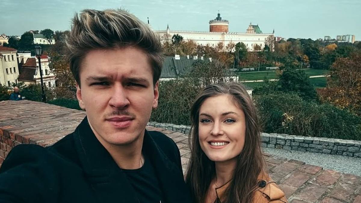 Para pozująca do selfie z widokiem na miasto w tle.