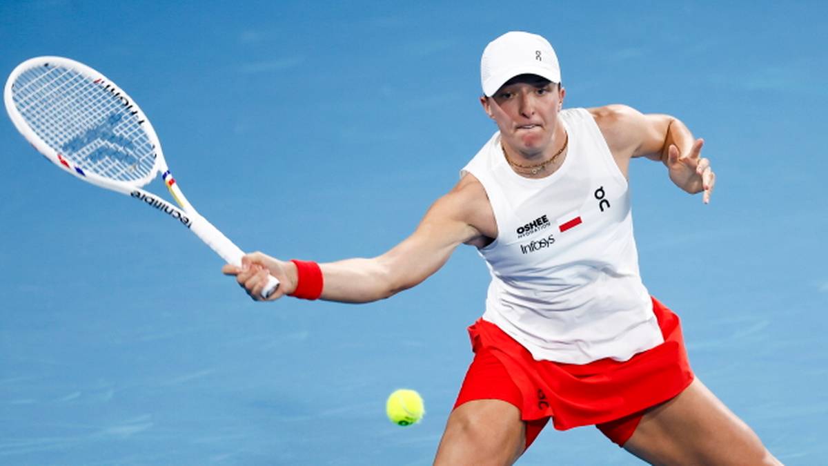 Tenisistka z białą czapką i rakietą odbija piłkę tenisową.