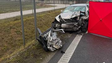 Zniszczone samochody po wypadku drogowym na poboczu drogi, obok widoczny znak drogowy "Prząsław" i czerwony namiot