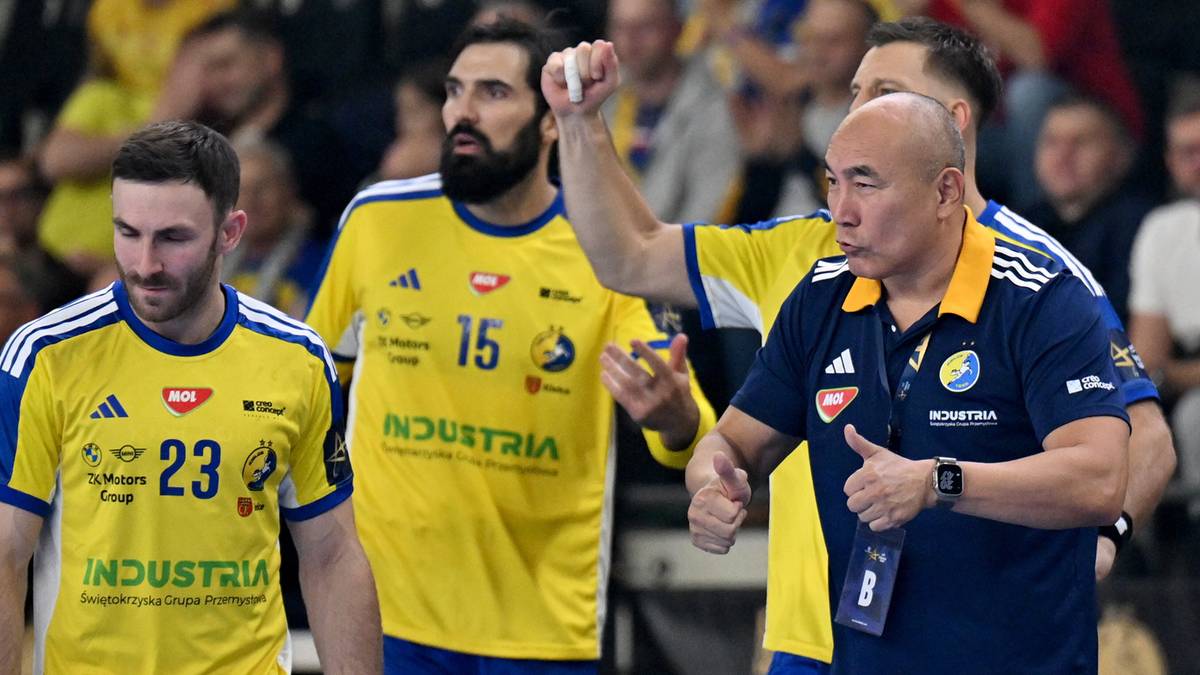 Trzech mężczyzn, dwóch w żółtych strojach sportowych z numerami 23 i 15, jeden w granatowej koszulce trenera, podczas meczu piłki ręcznej.