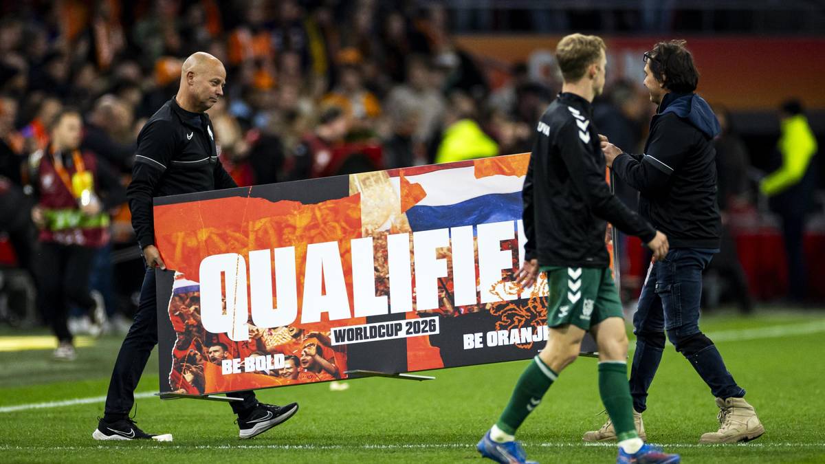 Dwie osoby niosą baner z napisem "QUALIFIED" i logiem "WORLD CUP 2026"