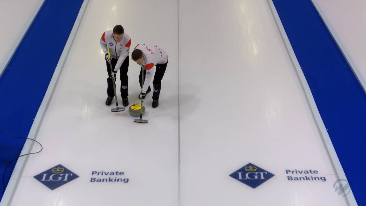 Dwóch graczy w curling na lodzie, jeden z miotłą.