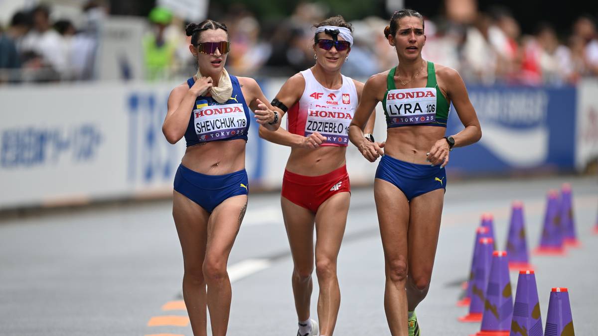 Trzy sportsmenki w strojach sportowych podczas zawodów w chodzie sportowym.