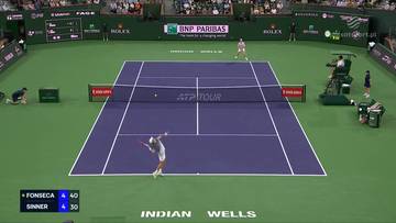 Kort tenisowy z zawodnikami w akcji, widoczne wyniki meczu Joao Fonseca - Jannik Sinner.