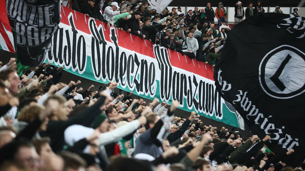 Tłum kibiców Legii Warszawa z transparentami i flagami