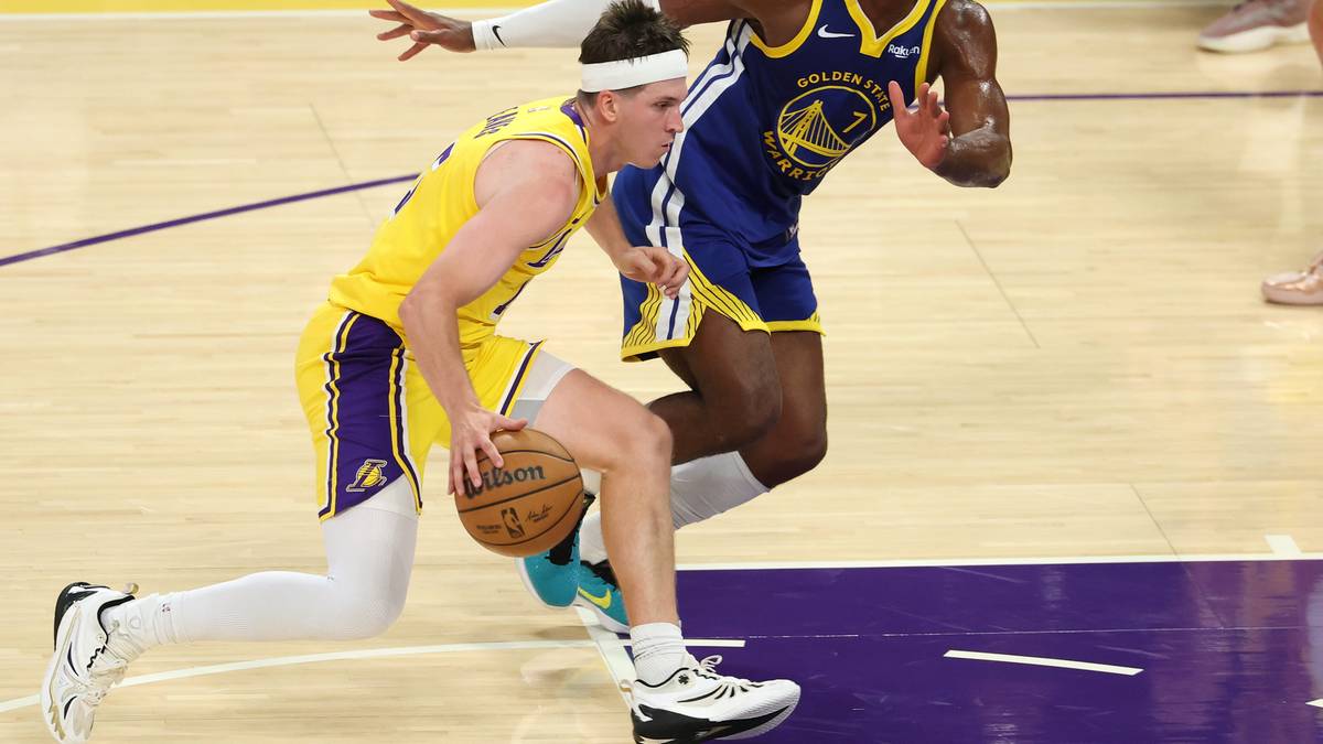 Dwóch zawodników Los Angeles Lakers w żółtych strojach, jeden prowadzi piłkę.