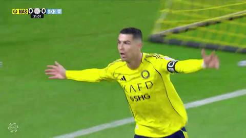Cristiano Ronaldo w ż&oacute;łtej koszulce Al-Nassr świętuje zdobycie bramki, z rękami rozłożonymi na boki. W tle zielona murawa stadionu i fragment bramki.