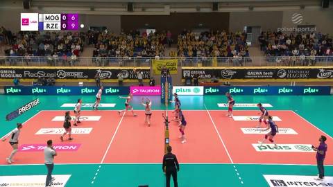 Mecz siatk&oacute;wki - Sok&oacute;ł vs Developres Rzesz&oacute;w. Widok na boisko z zawodniczkami po obu stronach siatki, trybuny zapełnione widzami. Wynik na tablicy 0:0.