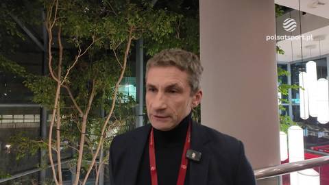 Remigiusz Rzepka, mężczyzna w czarnym golfie i marynarce, udziela wywiadu.