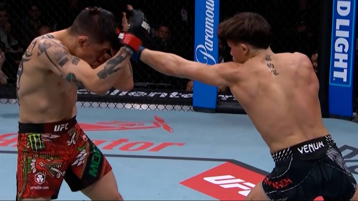 Dw&oacute;ch zawodnik&oacute;w MMA walczy w oktagonie, jeden wykonuje unik, drugi wyprowadza cios.