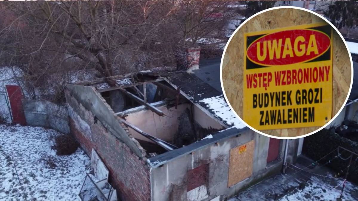 Zniszczony budynek z częściowo zawalonym dachem i tabliczką ostrzegawczą "UWAGA WSTĘP WZBRONIONY BUDYNEK GROZI ZAWALENIEM".