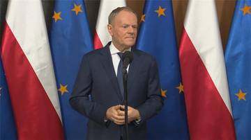 Premier Donald Tusk przemawia na tle flag Polski i Unii Europejskiej.