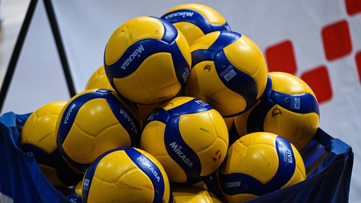 Stos ż&oacute;łto-niebieskich piłek do siatk&oacute;wki.