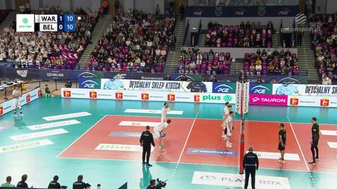 Siatkarze drużyny PGE Projekt Warszawa i PGE GiEK Skra Bełchat&oacute;w podczas meczu, widoczne trybuny z kibicami oraz wynik na telebimie.