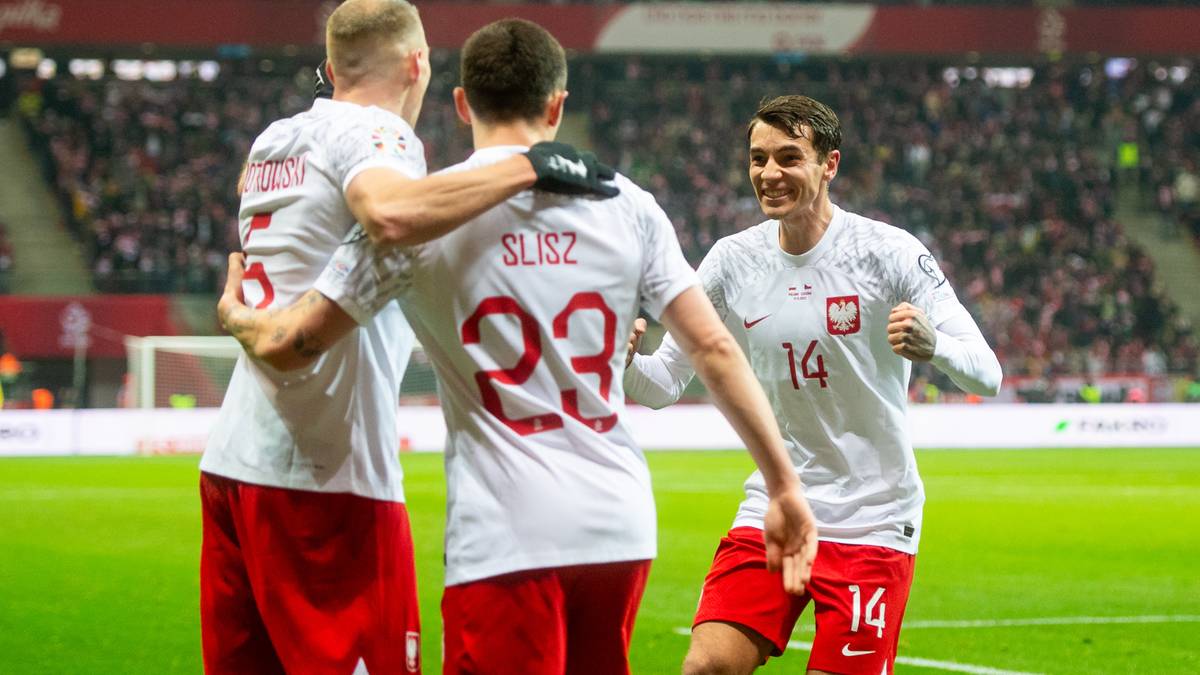 Trzech piłkarzy reprezentacji Polski świętuje gola, dw&oacute;ch przytula się, jeden klęczy.