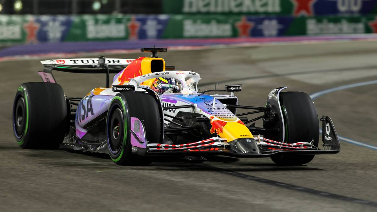 Kolorowy bolid Formuły 1 ściga się po torze.