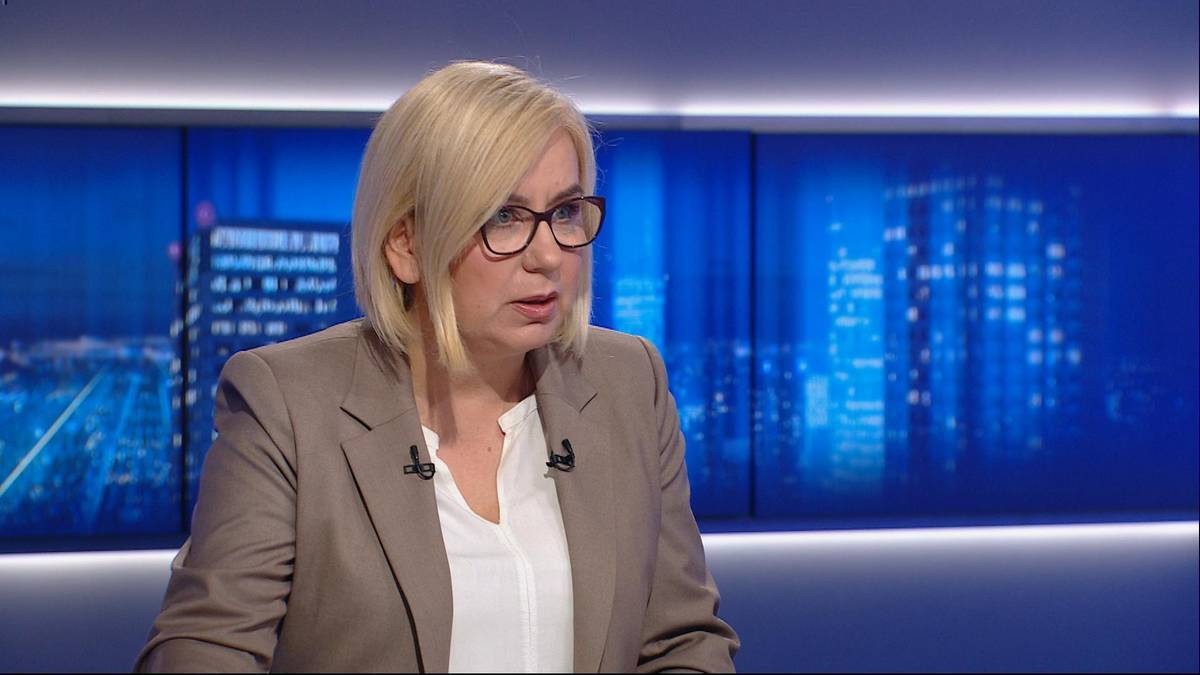 Kobieta w okularach siedzi w studiu telewizyjnym.