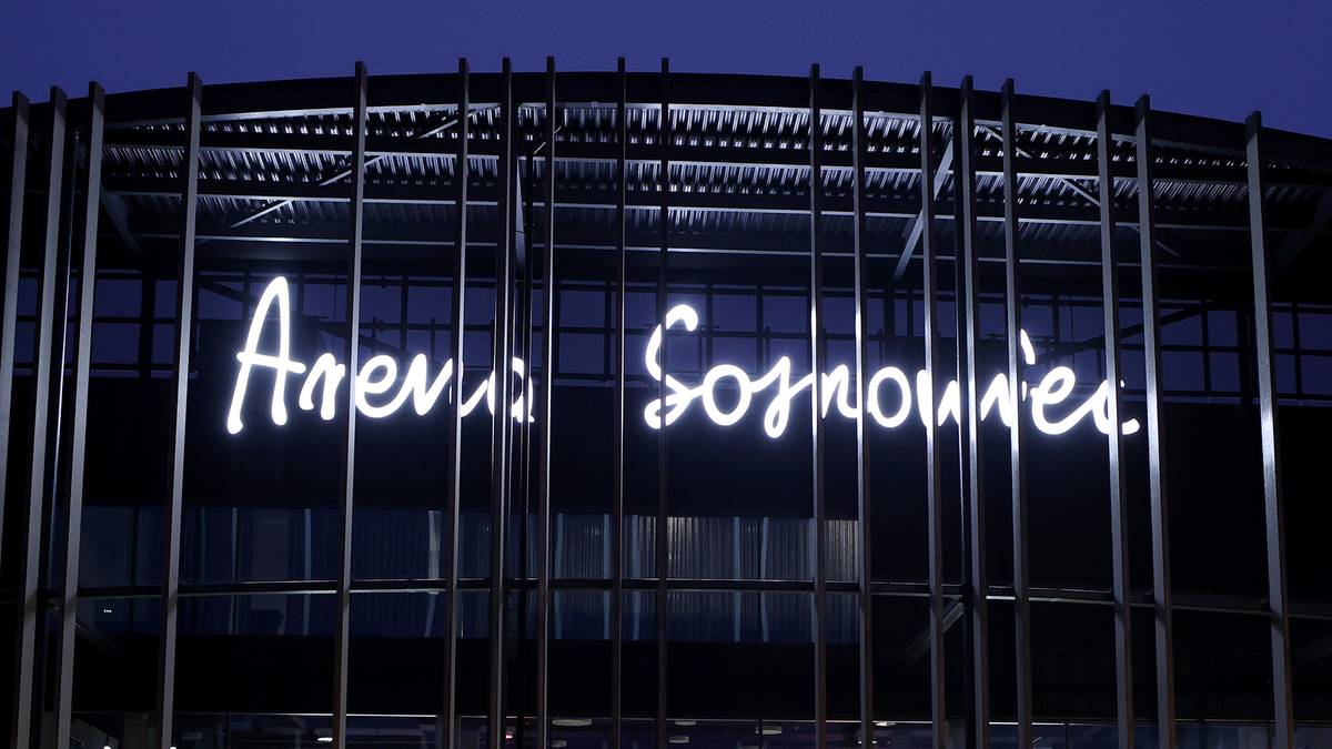 Neonowy napis "Arena Sosnowiec" na froncie nowoczesnego budynku.