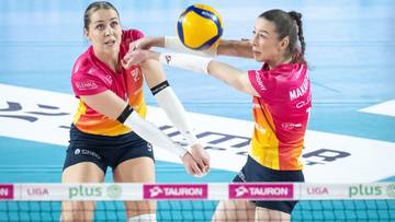 Dwie siatkarki walczą o przyjęcie piłki podczas meczu siatkówki.