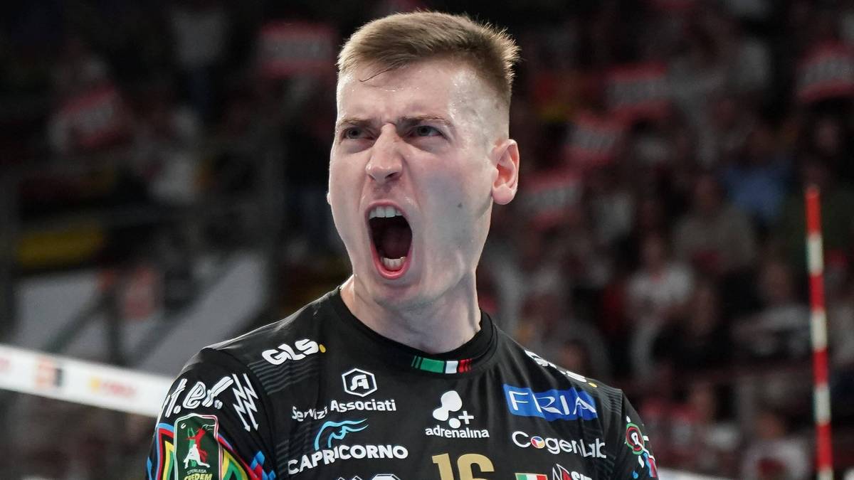 Siatkarz w czarnej koszulce z numerem 16 krzyczy z radości podczas meczu.