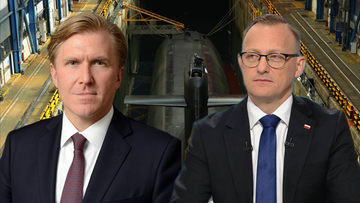 Dwie osoby ubrane w garnitury, na dalszym planie widać wnętrze stoczni z łodzią podwodną.