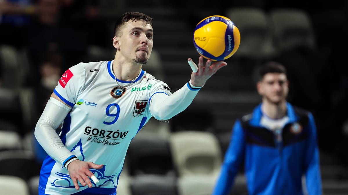 Siatkarz w białej koszulce z numerem 9 i napisem "GORZÓW" trzyma piłkę do siatkówki na palcu podczas meczu.