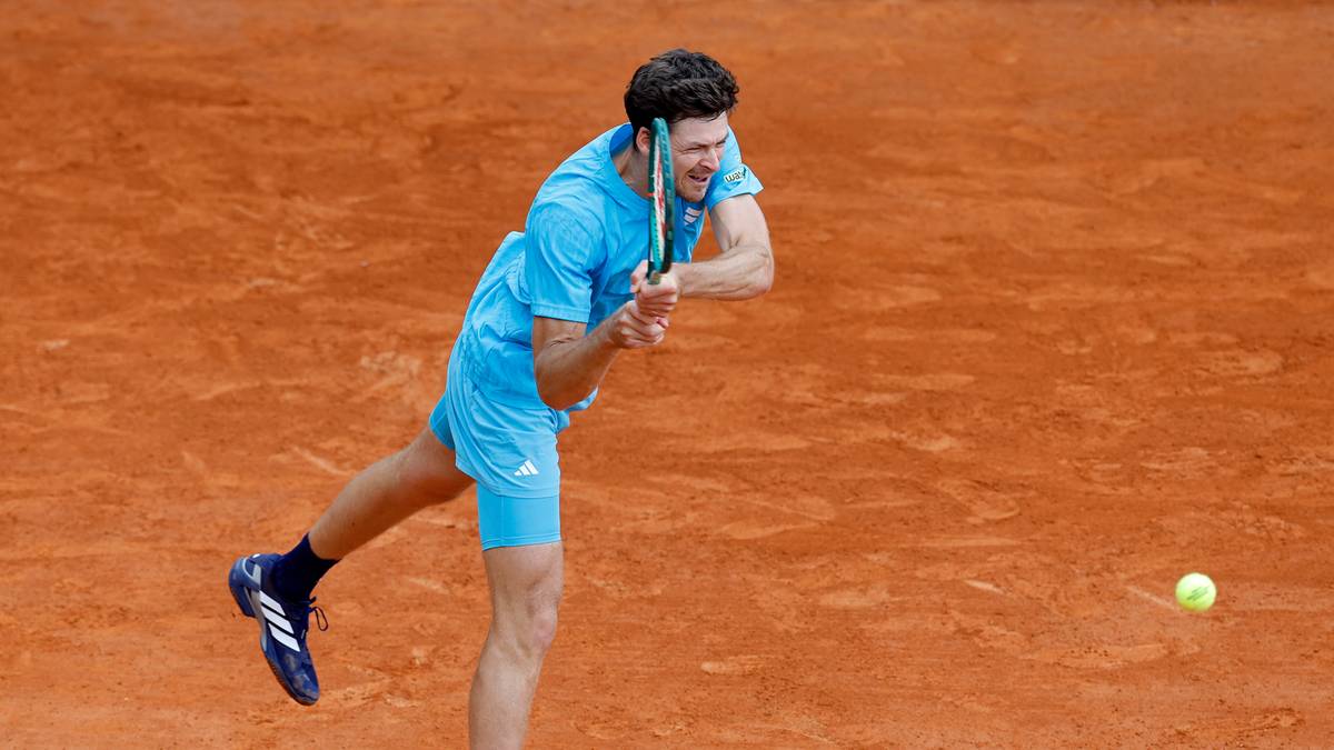 Hubert Hurkacz wykonuje serwis podczas meczu tenisowego na korcie ziemnym.