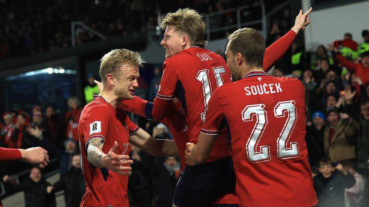 Piłkarze Czech w czerwonych strojach świętują zwycięstwo, jeden z nich ma na plecach numer 22.