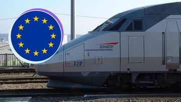 Zbliżenie na prz&oacute;d nowoczesnego pociągu TGV z logo SNCF, obok kt&oacute;rego znajduje się okrąg z flagą Unii Europejskiej.