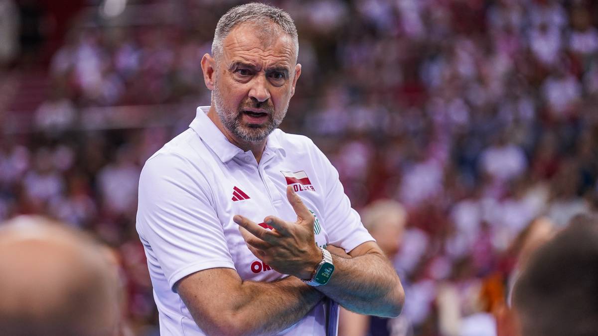 Nikola Grbić, trener reprezentacji Polski w siatkówce, w białej koszulce z logo, gestykuluje podczas meczu.