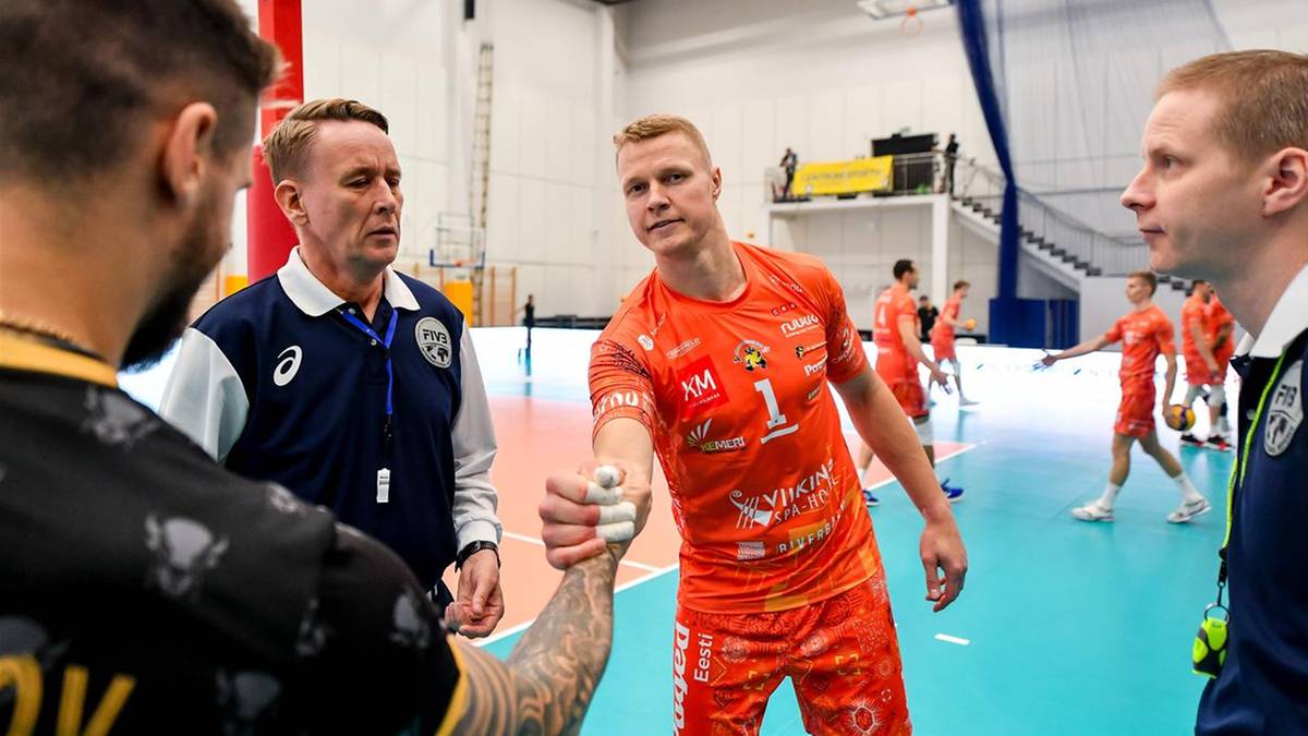 Siatkarze podają sobie ręce na boisku.