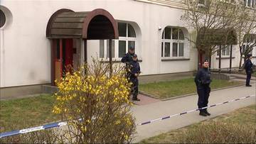 Budynek mieszkalny z policjantami i taśmą policyjną zabezpieczającą teren.
