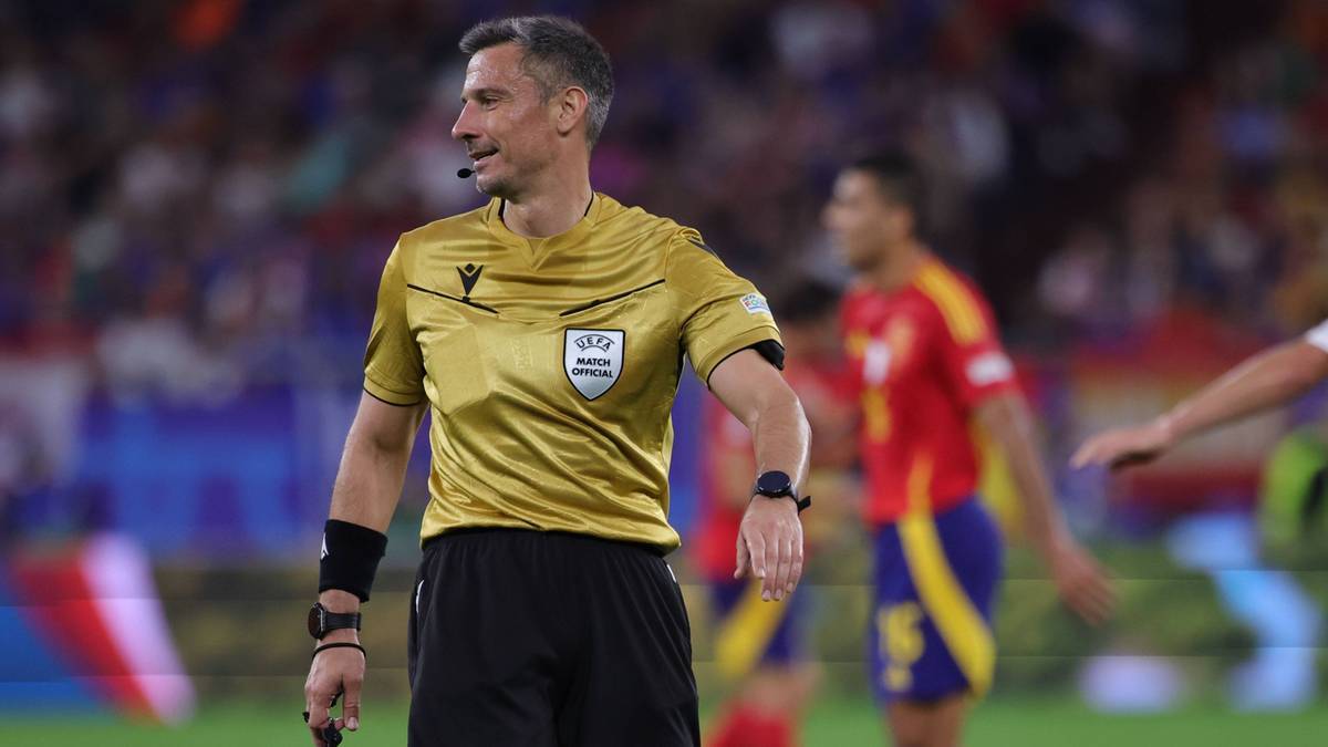 Sędzia piłkarski w złotym stroju na boisku.