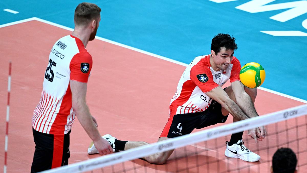 Siatkarz w czerwono-białym stroju odbija piłkę podczas meczu Ligi Mistrz&oacute;w.