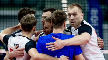 Siatkarze w geście jedności na boisku siatkarskim.