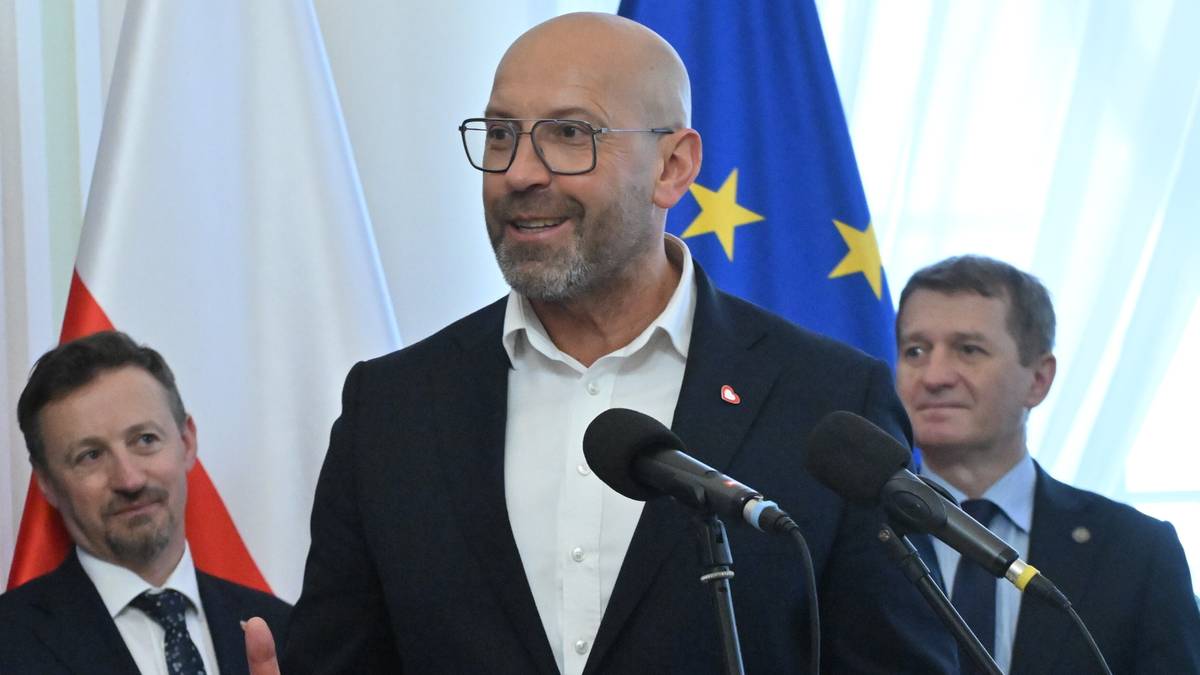 Minister Sportu i Turystyki Jakub Rutnicki przemawia, obok stoi młody polski sportowiec.