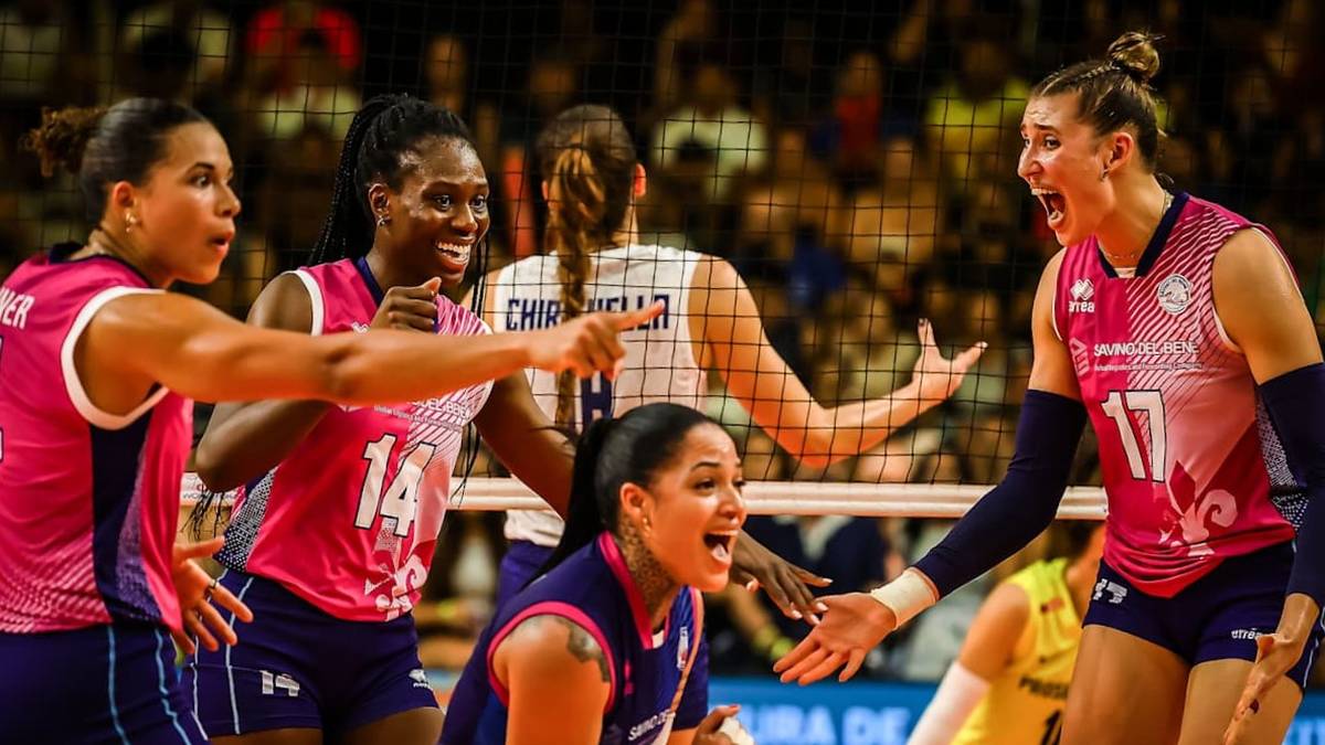 Siatkarki w białych i różowych strojach rywalizują na boisku.