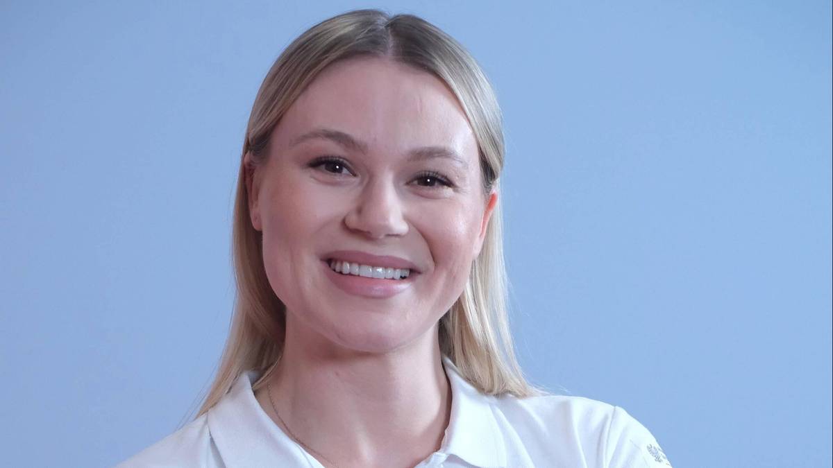 Uśmiechnięta blondynka w białej koszuli