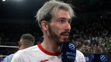 Tomasz Fornal w biało-czerwonej koszulce udziela wywiadu, trzymając mikrofon z l