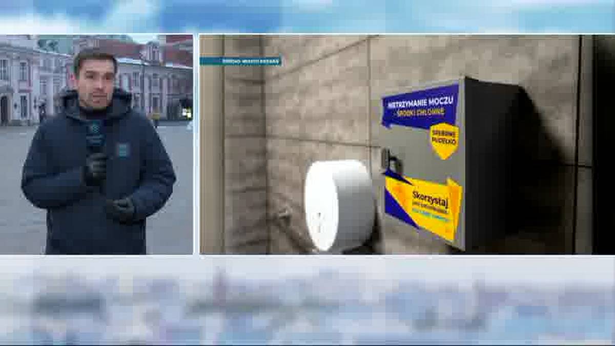 Mężczyzna z mikrofonem obok pojemnika na ścianie.