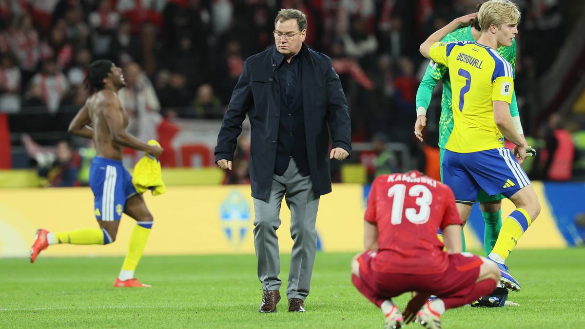 Trener reprezentacji Polski Jan Urban na boisku piłkarskim, otoczony przez zawodnik&oacute;w w barwach narodowych podczas meczu.