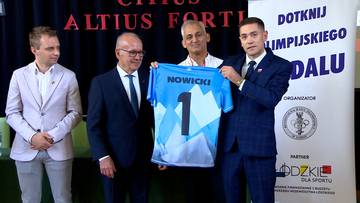 Czterech mężczyzn podczas ceremonii wręczenia koszulki z numerem 1 i nazwiskiem "NOWICKI".