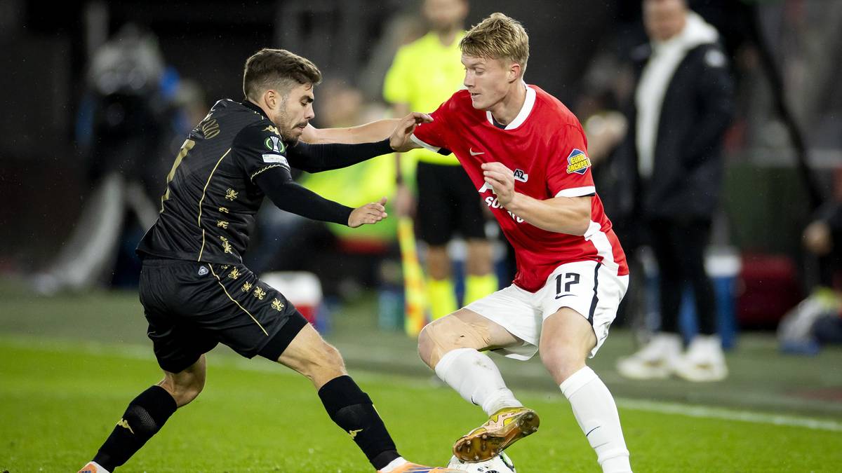 Dw&oacute;ch piłkarzy walczących o piłkę na boisku.