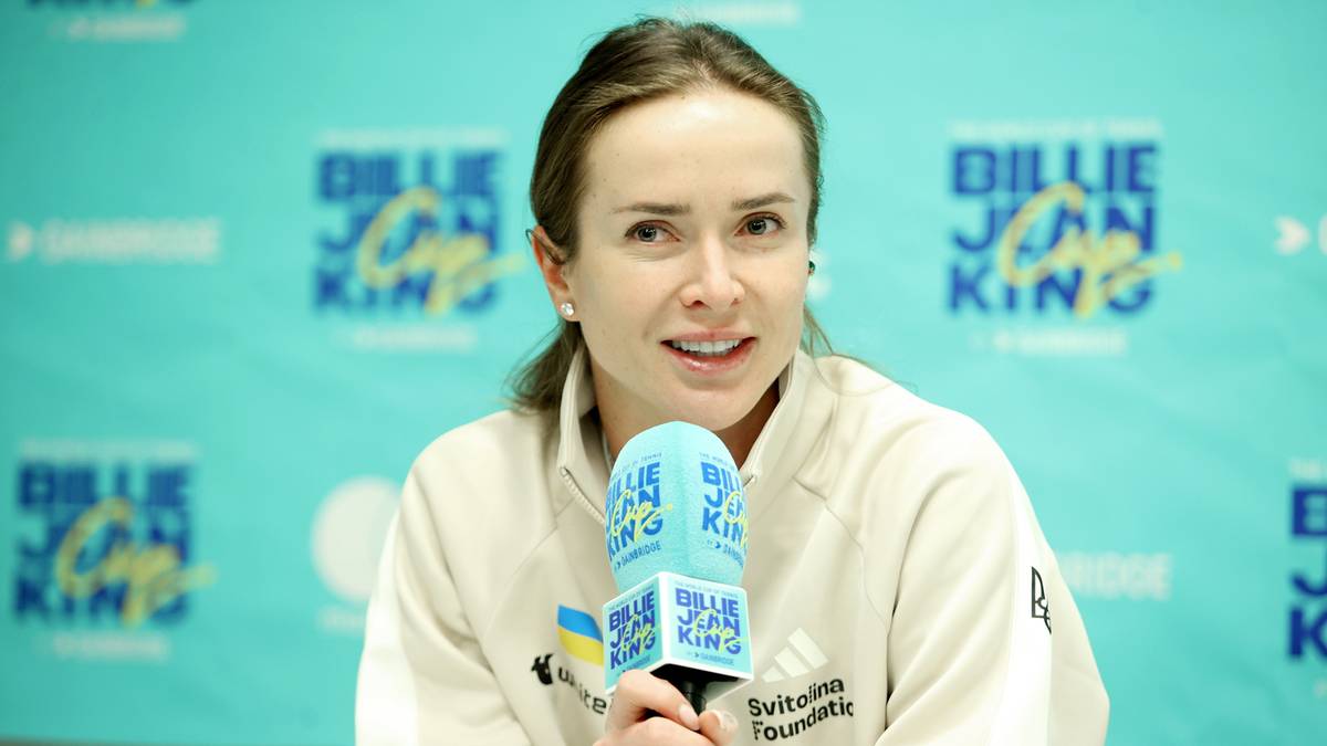 Tenisistka udzielająca wywiadu przy mikrofonie z logo Billie Jean King Cup w tle.
