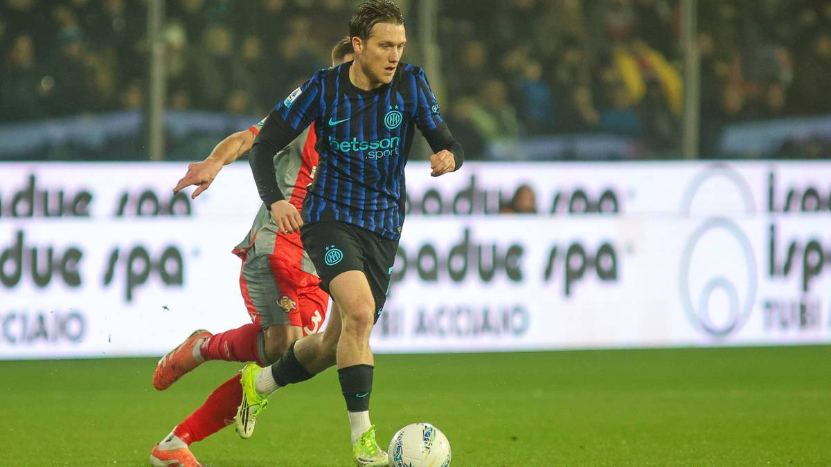 Piłkarz Interu Mediolan Piotr Zieliński w niebiesko-czarnej koszulce prowadzi piłkę na boisku.